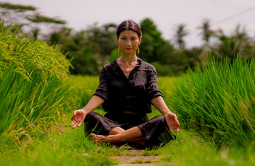 outdoors yoga and meditation at rice field - attractive and happy middle aged Asian Chinese woman enjoying yoga and relaxation in connection with the nature