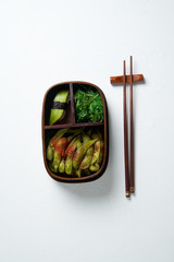 Asian food with freash vedeterian meals in wooden bento box from a restaurant. Delivery of ready-made food.