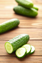 Fresh cucumber slices on brown wooden background.