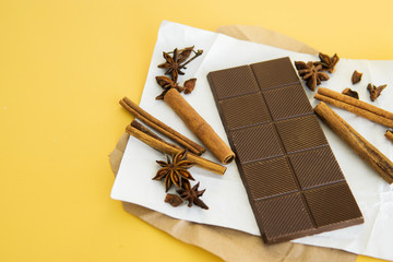 Milk chocolate and cinnamon sticks close-up. Photos in warm colors. Sweetness. World chocolate day....