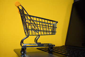 End of online sales. Online shopping, shopping cart on laptop keyboard.