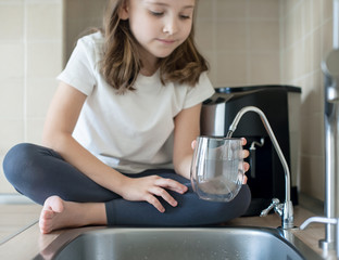 Little child open water tap. Kitchen faucet. Glass of clean water. Pouring fresh drink. Hydration....