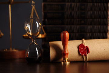 Wooden gavel, hourglass, books and stamp on testament and last will on wooden table. Notary public...