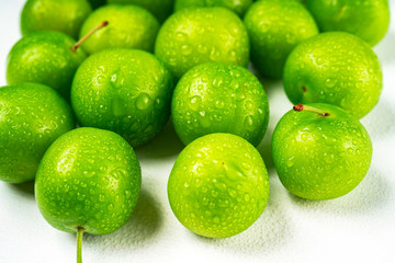 Close-up macro fresh green sour plum. Greengage on white background.  