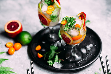 Lemonade with orange, lime, kumquat and mint in a glass
