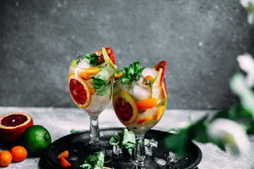 Lemonade with orange, lime, kumquat and mint in a glass