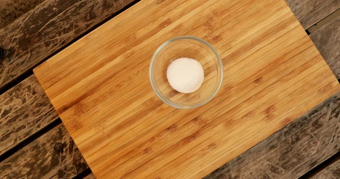 Bringing a little bowl of baking powder on a wooden table