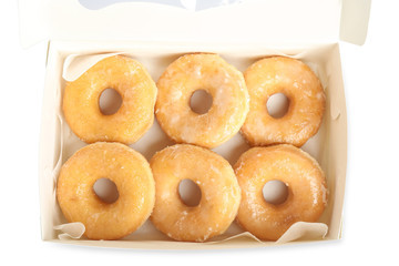 Delicious donuts in box isolated on white, top view