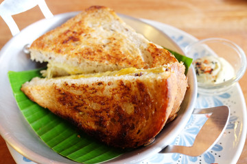 Butter on Bread Toast with sauce on banana leave in pan and white dish is homemade breakfast.