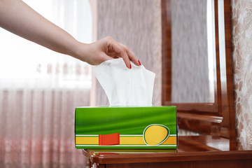 female hand pulls a napkin out of the box