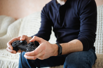 A man plays video games with a joystick in his hands