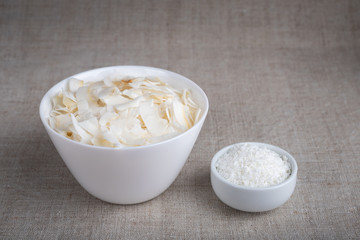 Coconut chips and shavings in a bowl on a cloth tablecloth