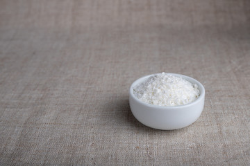 Coconut flakes in a bowl on the table