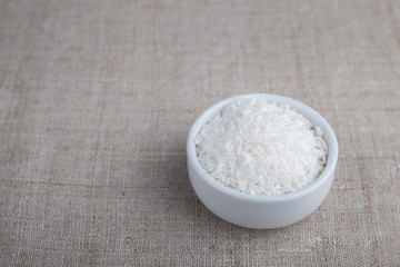 Coconut flakes in a bowl on the table