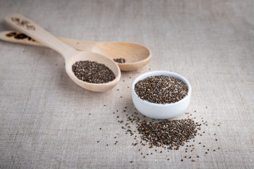 Chia seed in a bowl and on a wooden spoon on the table