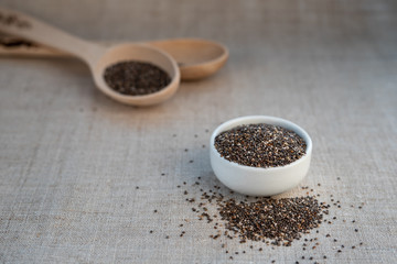 Chia seed in a bowl and on a wooden spoon on the table