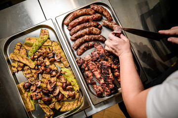 Top view of two metal trays with grilled meat and vegetables