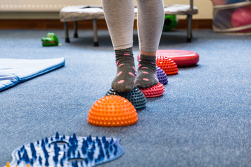 
Pediatric Sensory Integration Therapy - a child walking on a sensory mat and pillows (close-up picture) - obrazy, fototapety, plakaty