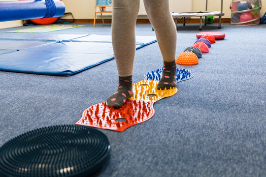 
Pediatric Sensory Integration Therapy - a child walking on a sensory mat and pillows (close-up picture)