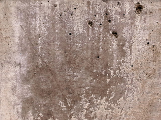 A close up view of an old concrete fence. Weathered wall with visible holes. Background texture. Horizontal view. 