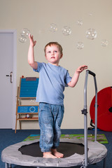 Pediatric Sensory Integration Therapy - a boy jumping on the trampoline and catching soap bubbles
