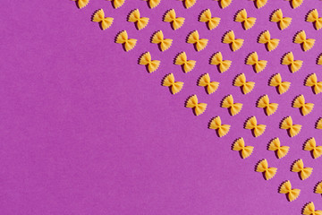 Raw pasta farfalle on purple background. Poster.