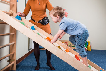 Pediatric Sensory Integration Therapy - a boy on climbing wall