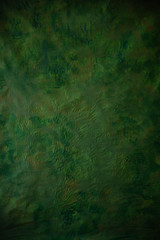 texture crumpled background of green color close-up, crumpled and with various bulges in structure, specks of paint of different colors, khaki color,