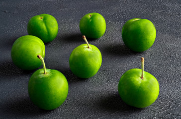 close-up macro fresh green sour plum. Greengage on dark background.