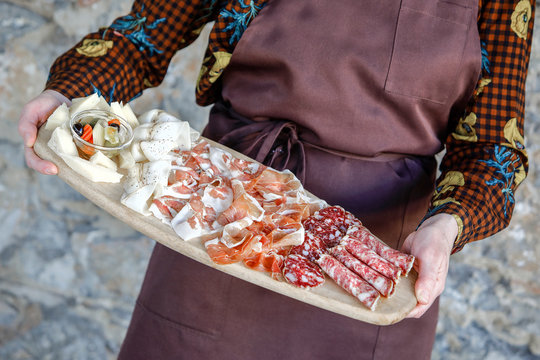 cameriere serve tagliere di affettati