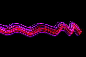 Long exposure photograph of neon colour in an abstract swirl, parallel lines pattern against a black background. Light painting photography.