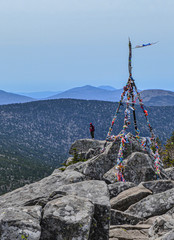 A man stands on top of a mountain, a man has reached the top. The mountain is called Pidan or...