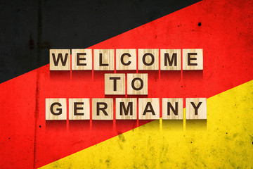 Welcome to Germany. The inscription on wooden blocks on the background of the flag of Germany.