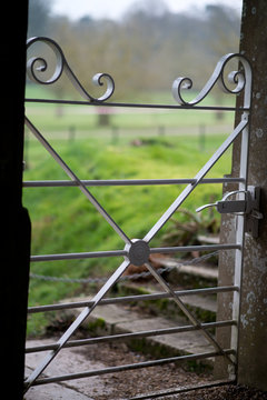 Close Up Of An Elegant White Metal Garden Gate With Stone Gateposts