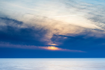 Vibrant cloudy summer sunset over ocean, Sweden