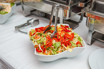 Fresh vitamin salad with red peppers, cabbage, carrots, served on the restaurant buffet table.