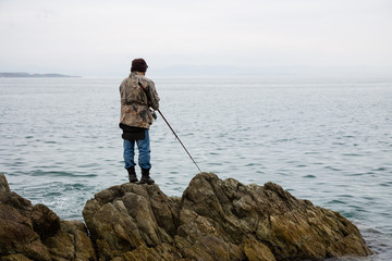 Fototapeta na wymiar Fisherman catches fish in the morning