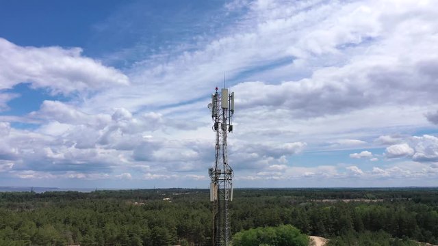 Closeup aerial shot of a telecommunication tower in a rural location. Telecommunication antennas and satellite dishes transmit 5g 4g cellular signals to consumers and smartphones