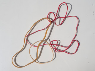 Red and yellow rubber bands on white background