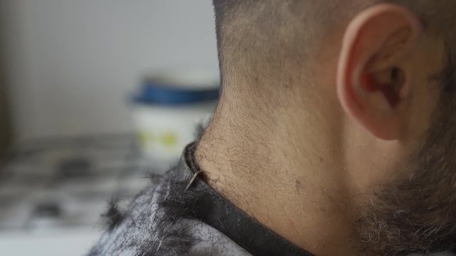 The hair falling on the shoulders of a young guy who came to get a haircut after loosening quarantine coronavirus. Focus on the shoulders of the client. Prores 422. 