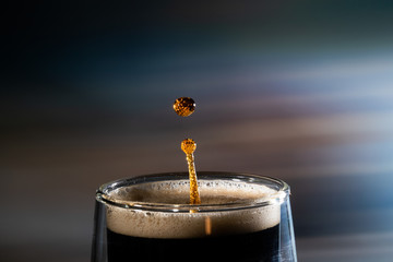 Coffee splash. Reaction of a falling drop on the hot, steaming and frothy coffee surface in a...