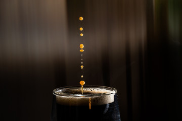 Coffee splash. Reaction of a falling drop on the hot, steaming and frothy coffee surface in a...