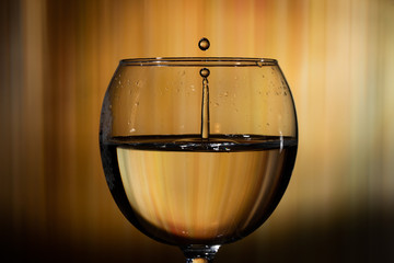 Water splash. Reaction of a falling drop on a cold water surface inside a modern glass transparent...