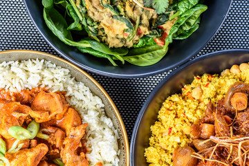 A trio of dishes including Butter Chicken, Vegetarian Dhal and Beef Bourguignon in round bowls