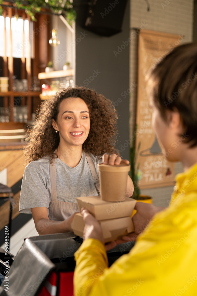 Poster Young smiling waitress helping courier with packing orders of clients