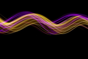 Long exposure photograph of neon pink and gold colour in an abstract swirl, parallel lines pattern against a black background. Light painting photography.
