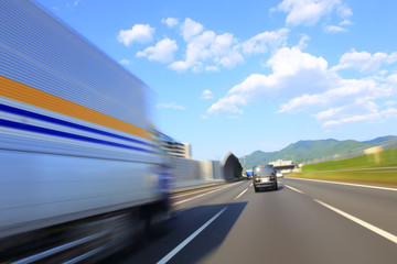 Naklejka na ściany i meble Speeding truck on the highway, motion blur