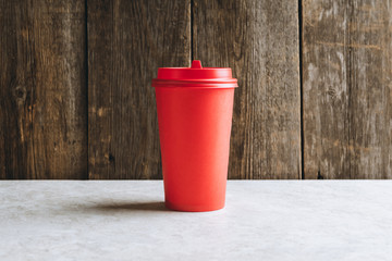 Plastic coffee cup for take away on the rustic wooden background. Selective focus. Shallow depth of field.