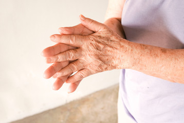 Aging hands of old asian woman rubbing together ,show a lot of freckles ,wrinkles and sagging on...