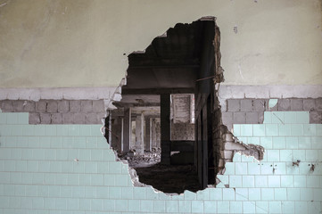 A hole in the wall of a large tiled building. Background
